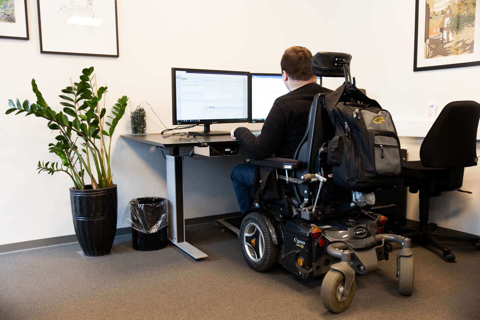 Young man in wheelchair working at desktop