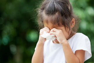 Sad little asian girl crying and holding tissue on her hand