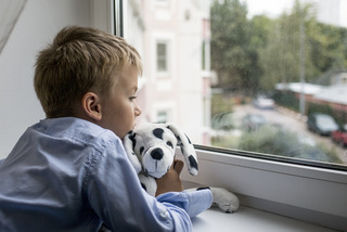 little boy with a toy near a window