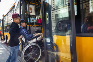 Man in wheelchair helped into the bus