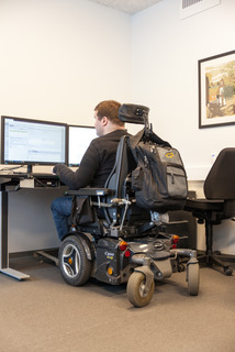 Young man in wheelchair working at desktop