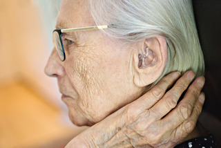 Elderly woman with hearing aid