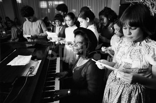 Mary Lou Williams. Playing piano with A girl choir, New York, 1975