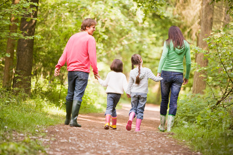 Family walking on path holding hands