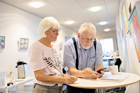 Elderly woman and man using smartphone