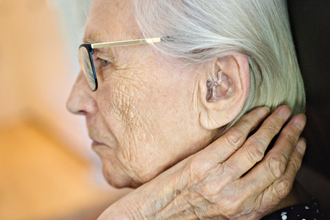 Elderly woman with hearing aid