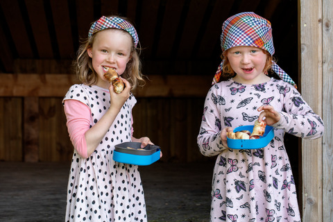 To piger hygger sig med at spise snobrød til spilopspejd