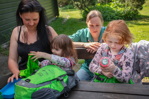 Piger og voksne kigger på rygsæk og insektglas til spilopspejd