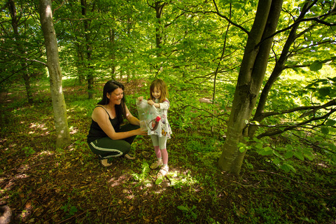 Voksen og pige finder syltetøj i plastikpose i skoven til spilopspejd