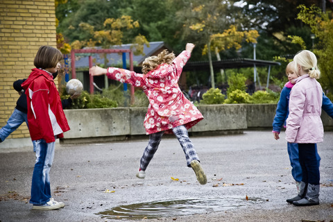 Børn der leger skolegården vand springer piger