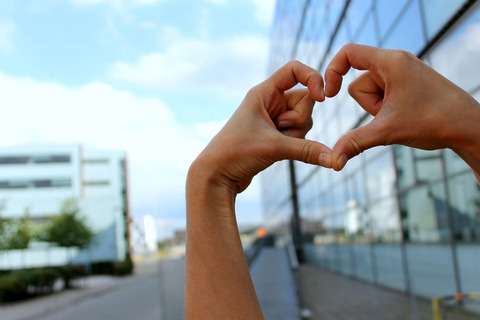 Hånd med hjerte foran designskolens bygning