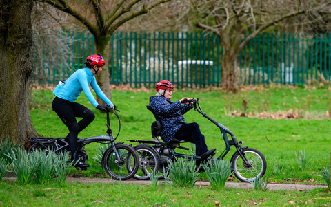 Dame Sarah Storey (left) pedals blue e-trike alongside participant through Debdale Park in Manchester on March 21 2023. Public event took place to mark the launch of Cycling UK's new e-cycle scheme, Making cycling e-asier, at Wheels for All.
