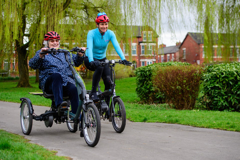 Dame Sarah Storey (right) smiles as she pedals blue e-trike alongside participant through Debdale Park in Manchester on March 21 2023. Public event took place to mark the launch of Cycling UK's new e-cycle scheme, Making cycling e-asier, at Wheels for All.