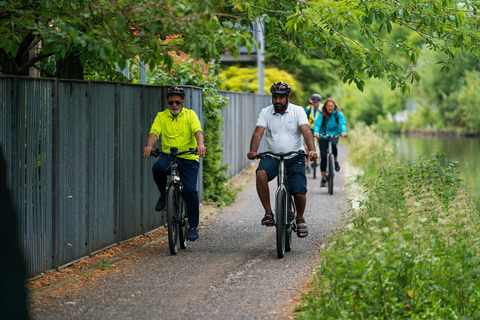 Participants pedal along canal during Making cycling e-asier 55km relay around Manchester to highlight the benefits of e-cycles