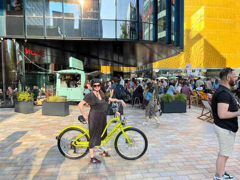 Lauren Cape-Davenhill sits on Making cycling e-asier yellow Townie e-cycle