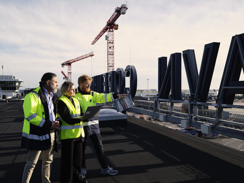 Medarbejdere på taget foran København skilt